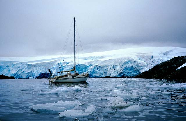 南極の氷の島とヨット、浮き氷に囲まれている。